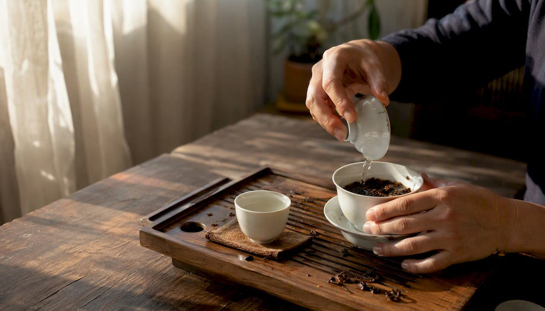 Hands rinsing pu-erh tea in gaiwan