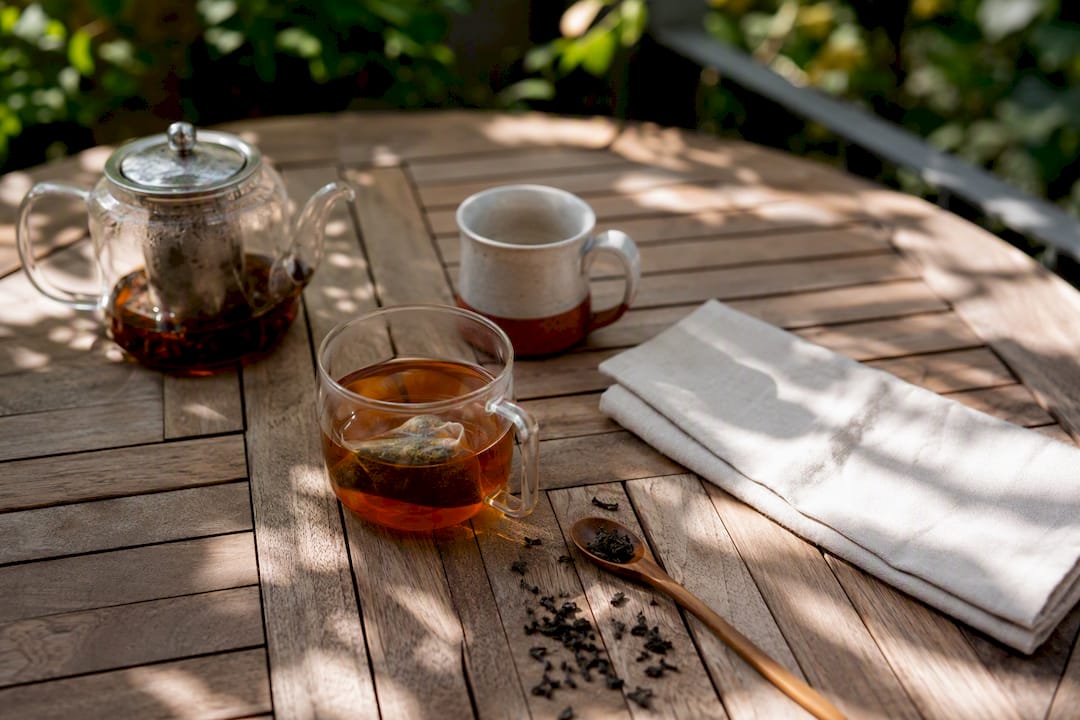 Tea pot with loose leaf and mug with tea bag side by side